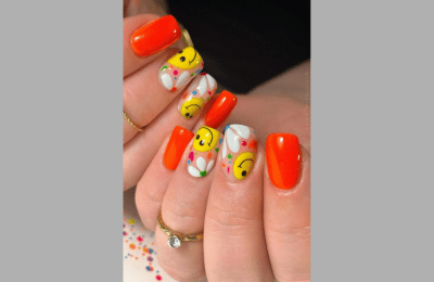 Orange nails with smiley faces for a bright, happy appearance
