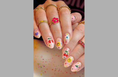 Vibrant pink-orange nails featuring smiley face accents