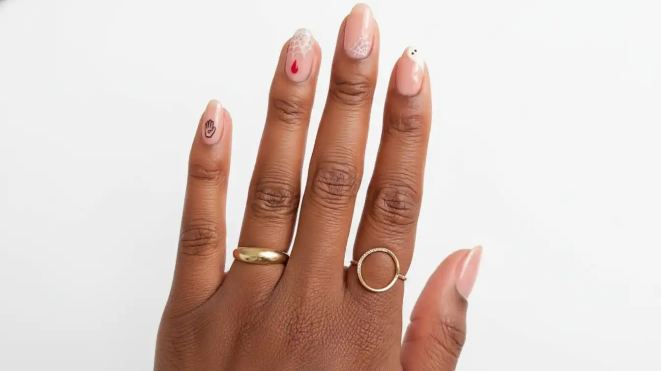 Sheer nude nails with tiny Halloween details - minimalist Halloween spider nail designs.