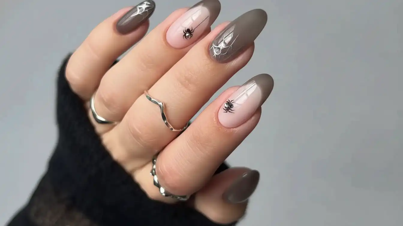 Chrome spider webs on sheer grey nails - shiny Halloween spider nail designs.